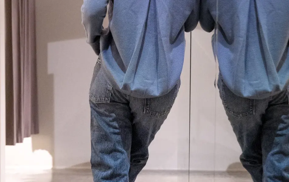 ryggen til dame med dueblå cardigan med legg-detalj på ryggen