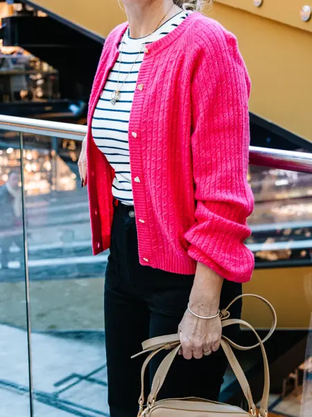 dame i vårklær står utenfor butikk