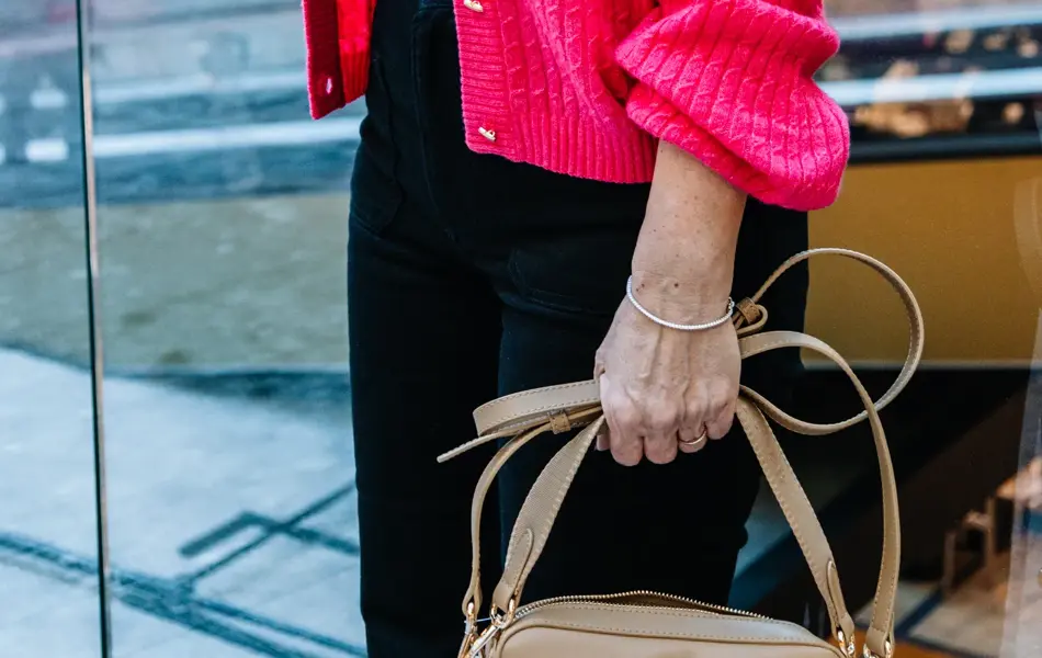 dame i vårklær står utenfor butikk