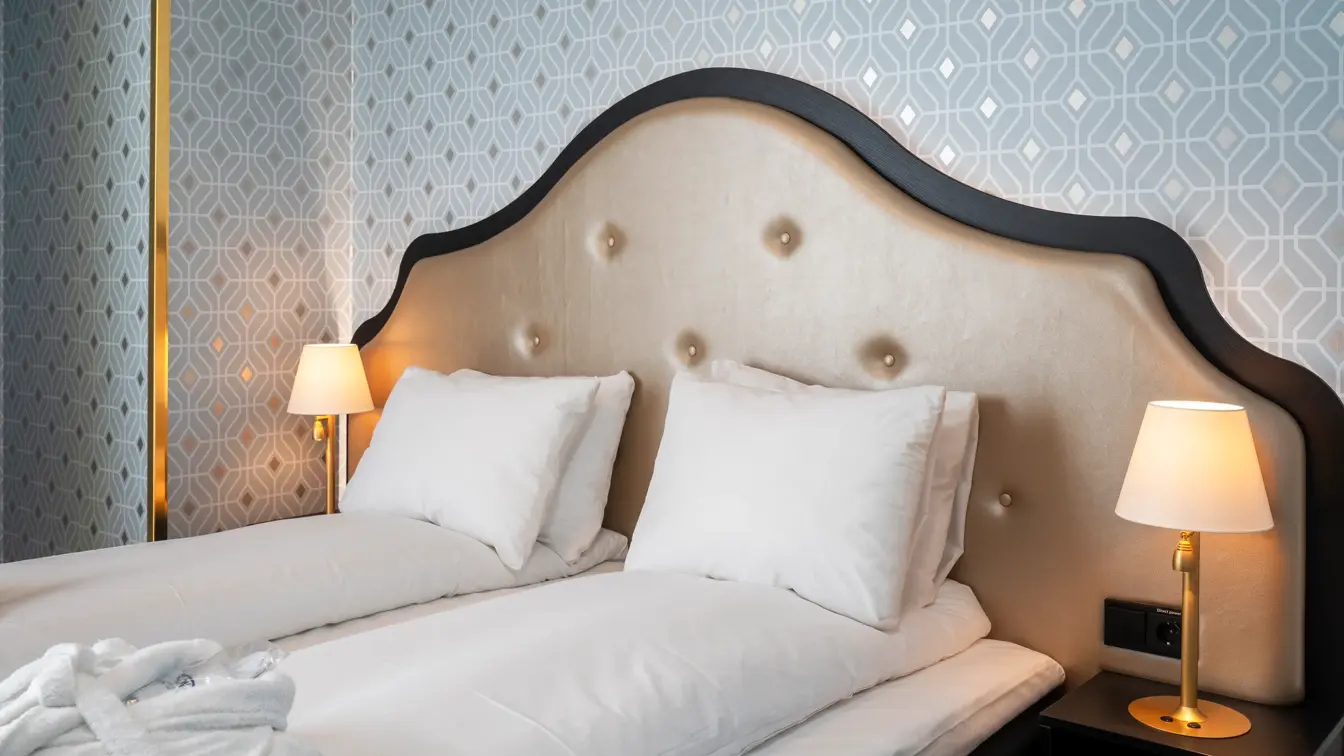 Dobbeltseng og mønstret sølv tapet i soverom i junior suite på Thon Hotel Cecil