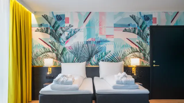 Separate senger og fargerik palmetapet i standard twin rom på Thon Hotel Storo