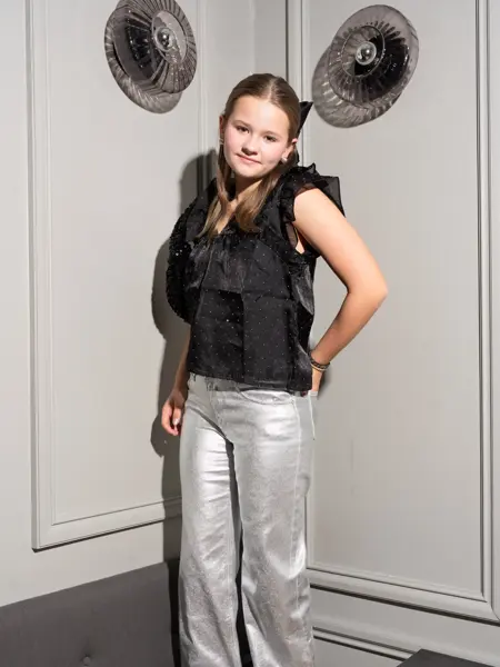 Jente i sølvbukser og svart topp