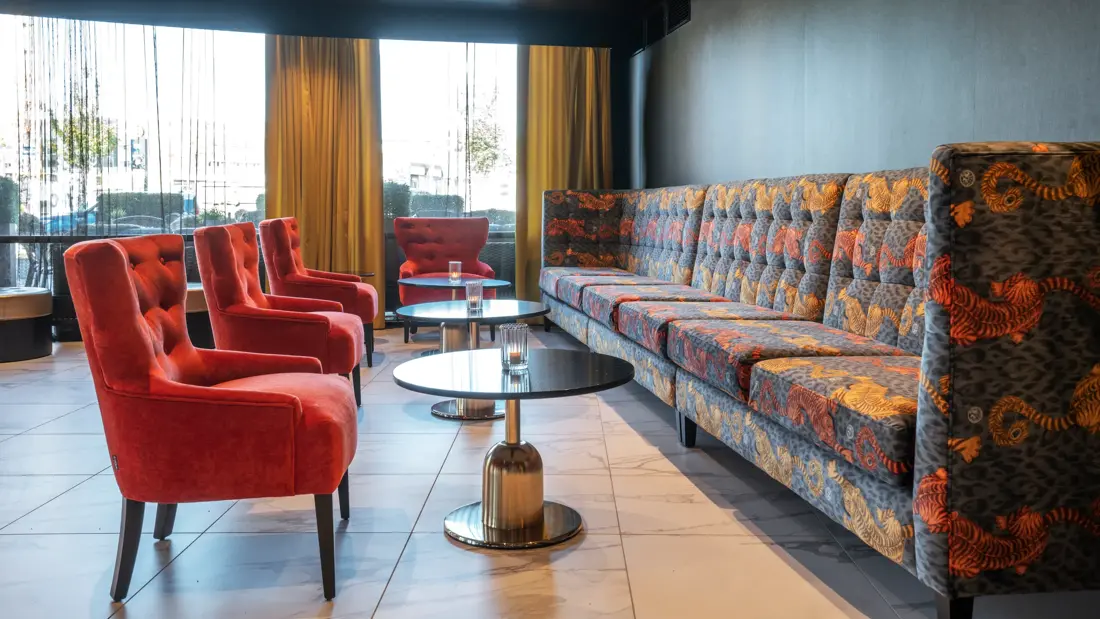 Røde lenestoler, sofa, salongbord, vindu 