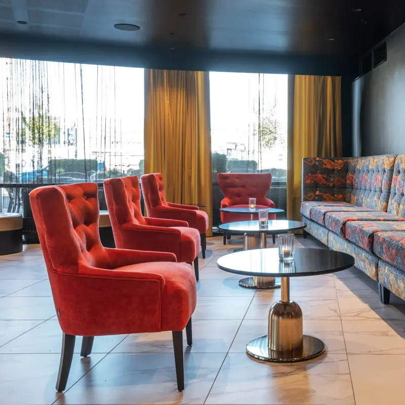 Røde lenestoler, sofa, salongbord, vindu 