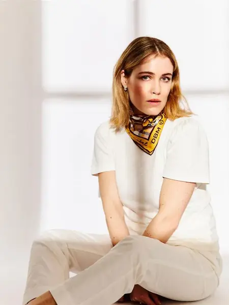 kvinne med nøytrale klær og sollys som kommer inn vinduet