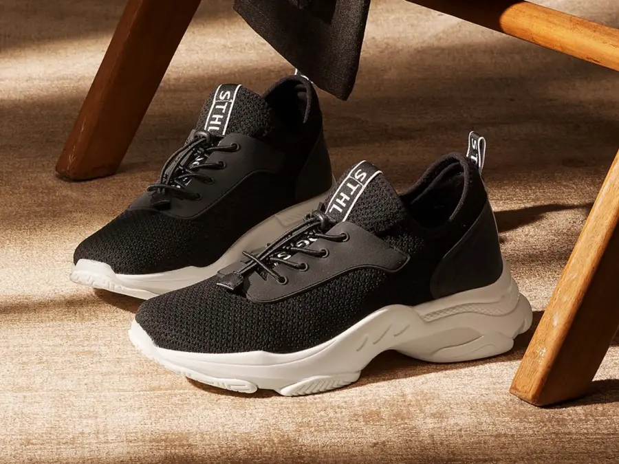 Svarte sko med lisser på gulvet