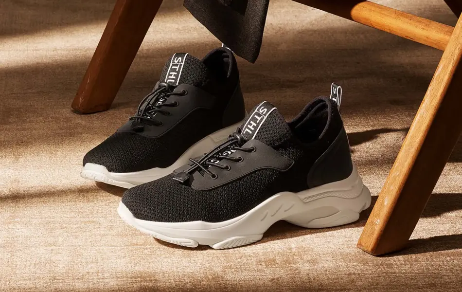 Svarte sko med lisser på gulvet