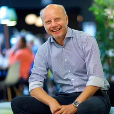 Senterleder Dag Einar Solberg sitter inne på senteret og smiler til kamera