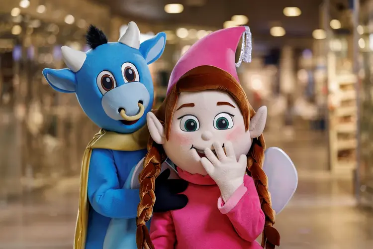 En blå okse figur i stoff og en fe med mørkt hår og rosa kjole alt i stoff