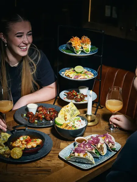 Person som smiler med mye mat på bordet