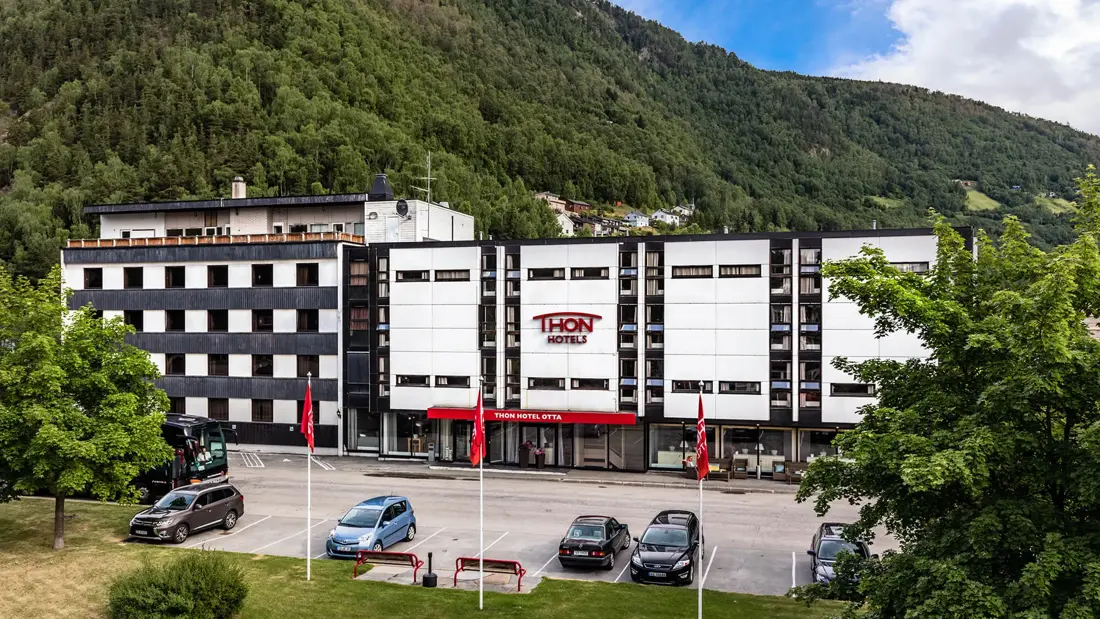 Fasadebilde av Thon Hotel Otta viser inngangen med biler utenfor