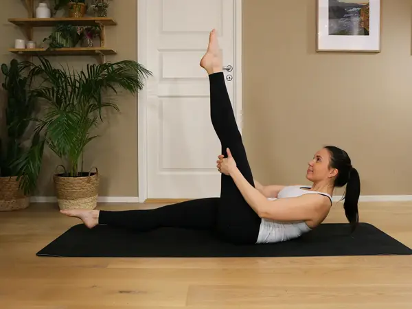 Anna viser Pilates-øvelser på treningsmatte på gulvet