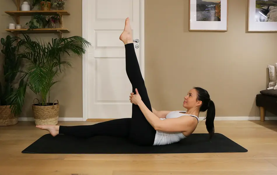 Anna viser Pilates-øvelser på treningsmatte på gulvet