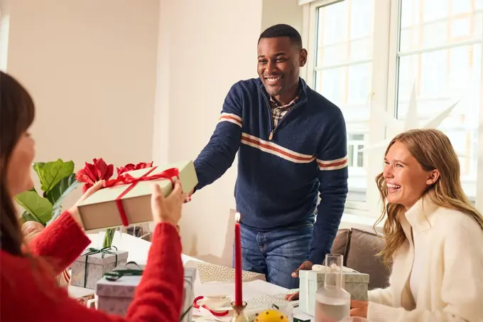 Mann som gir en julegave til noen