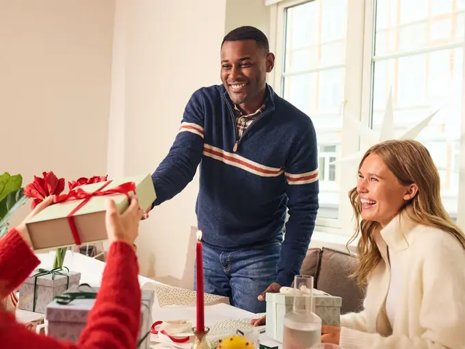 Mann som gir en julegave til noen