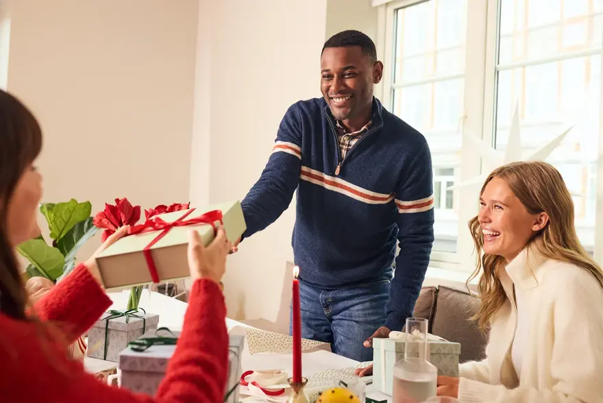 Mann som gir en julegave til noen