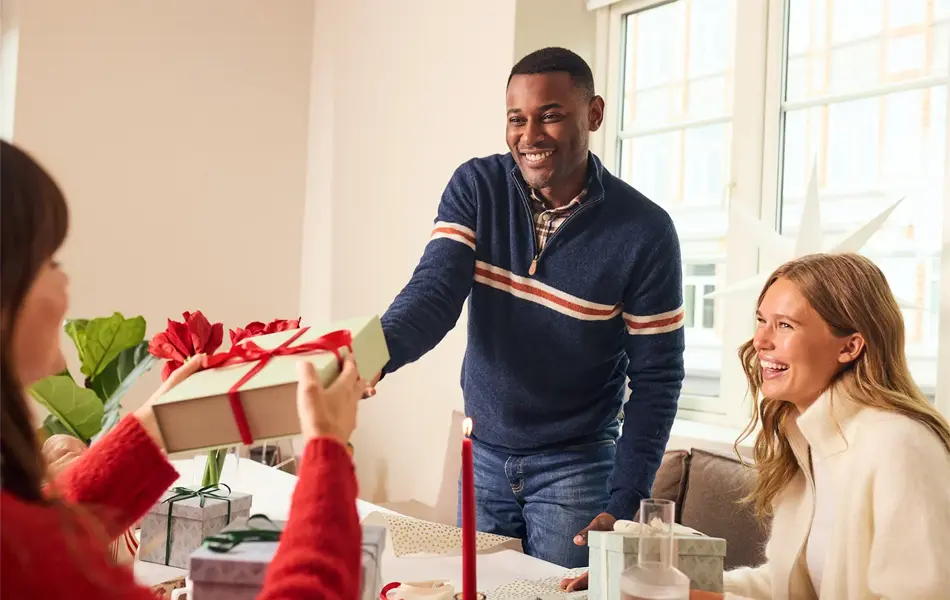 Mann som gir en julegave til noen