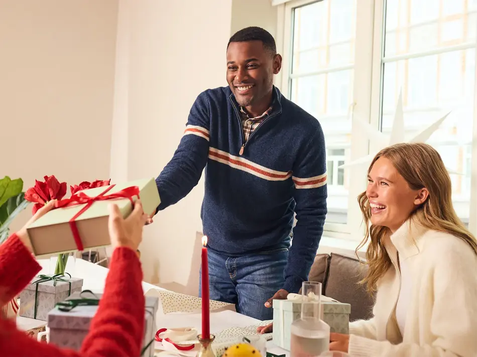 Mann som gir en julegave til noen