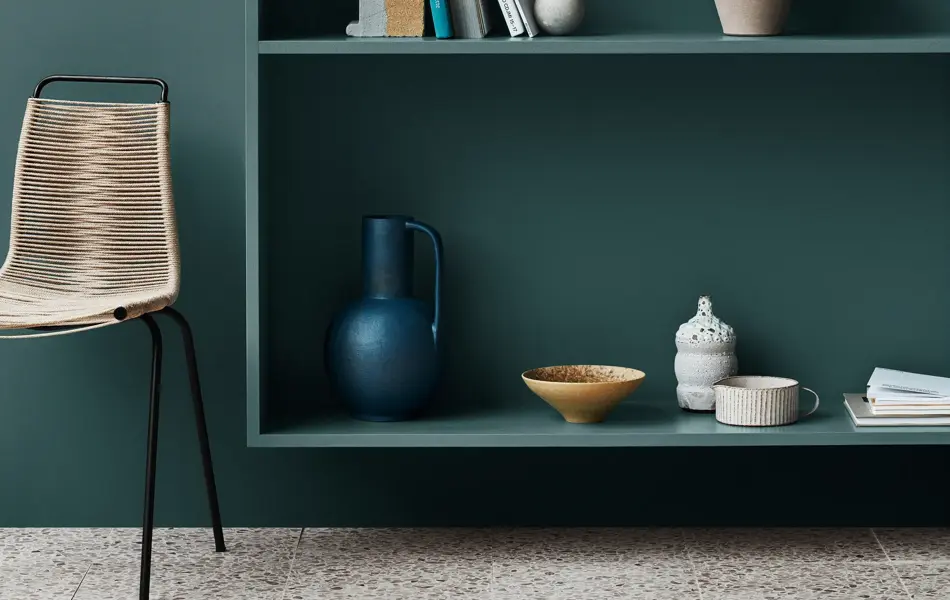 Grønnblå hylle som er malt i samme farge som veggen