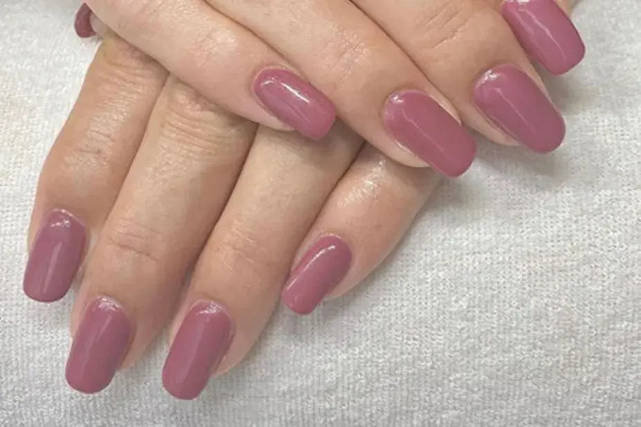 nærbilde av hender med nye negler, mauve neglelakk