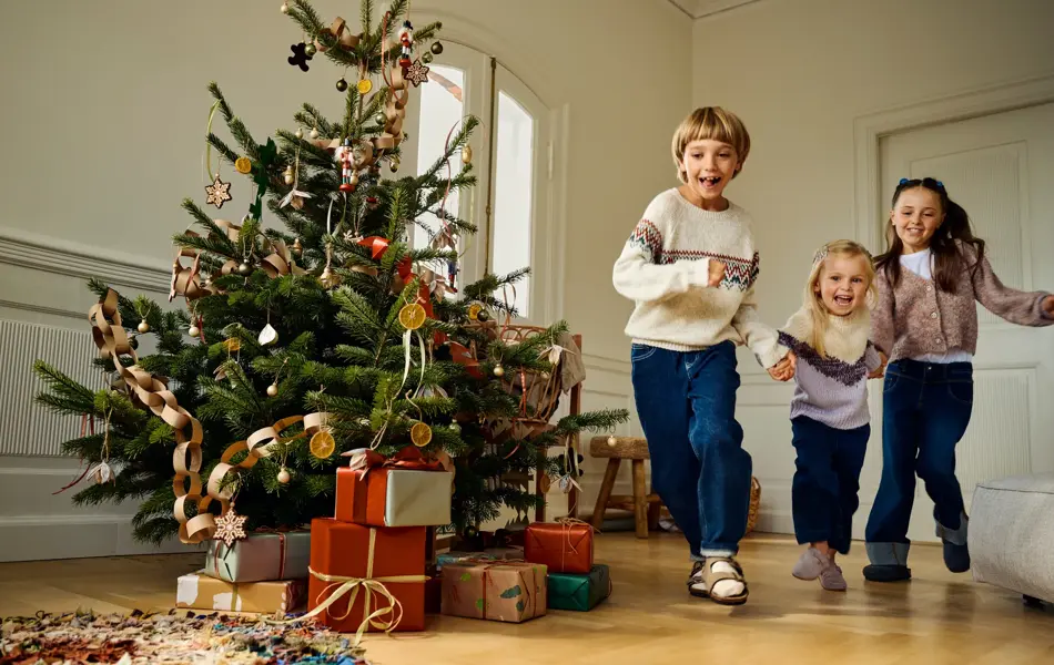 Barn som løper i en julepyntet stue