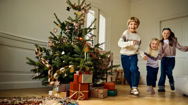 Barn som løper i en julepyntet stue