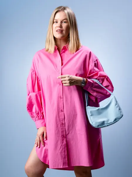 Vårens trender vist av en jente med halvlangt lyst hår og en jente med mørkt langt hår. Beige trenchcoat, kanll rosa skjorter og kjoler og bluser med puffermer