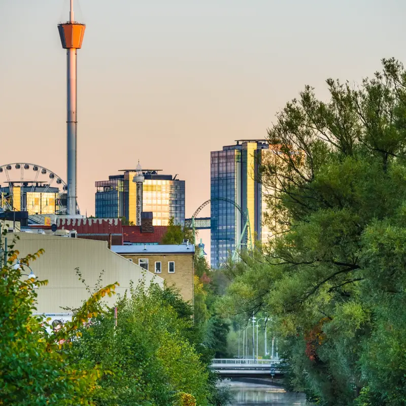To kajakkpadlere på elven i Gøteborg. I bakgrunnen ses skyskrapere, pariserhjul og utsiktstårnet AtmosFear/Lisebergtårnet