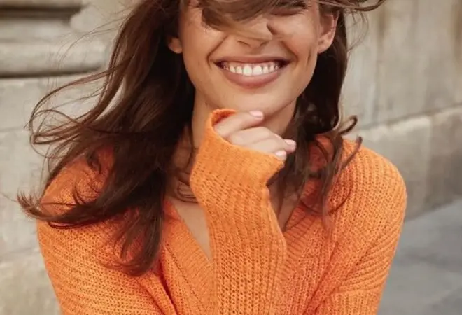 dame som smiler i orange genser