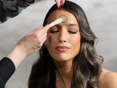 Damemodell blir sminket av sminkør