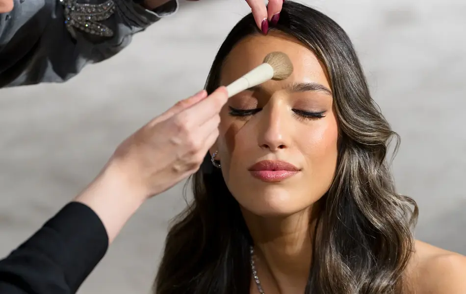 Damemodell blir sminket av sminkør