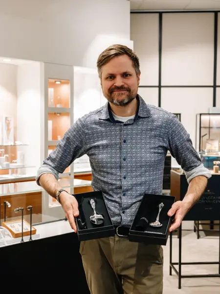 Mann som holder sølvbestikk