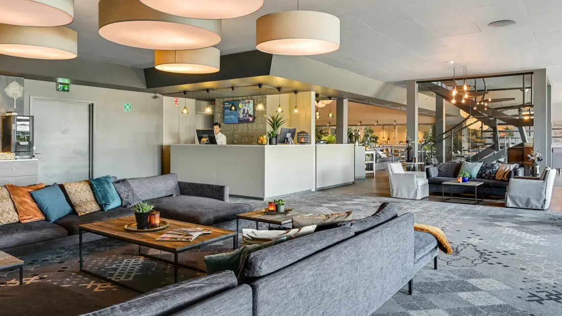 Resepsjon, sittegruppe, taklamper, hvite vegger.