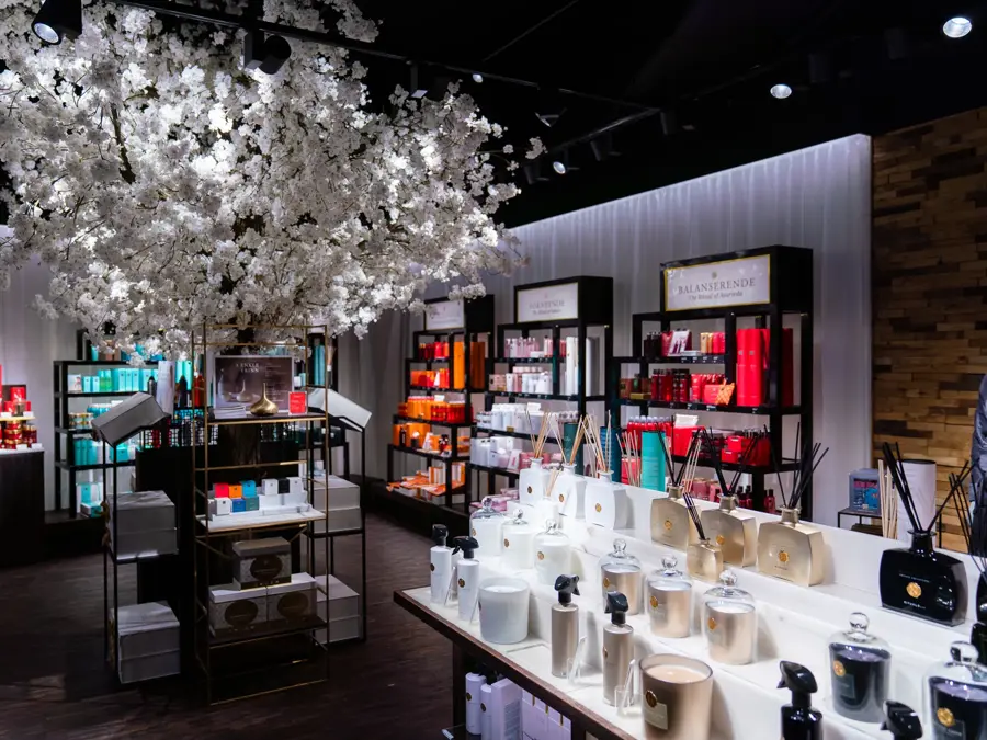 innsiden av butikken med et  hvitt stort tre i midten av rommet med velvære produkter rundt