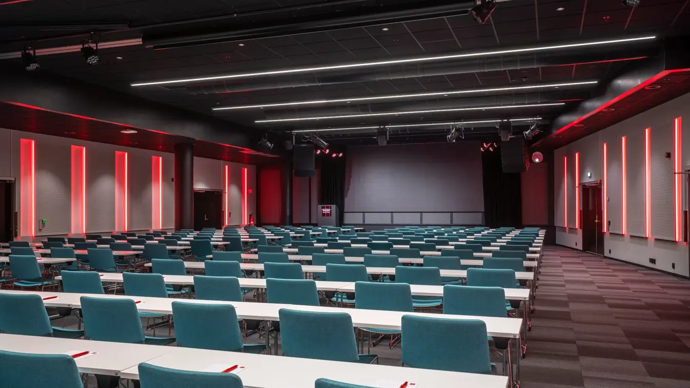 Storosalen hos Thon Hotel Storo, med klasseromsoppsett og med rød belysning på veggene.