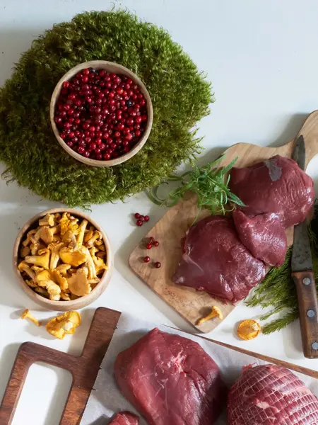 Kjøtt, sopp i en skål og en skål med tyttebær