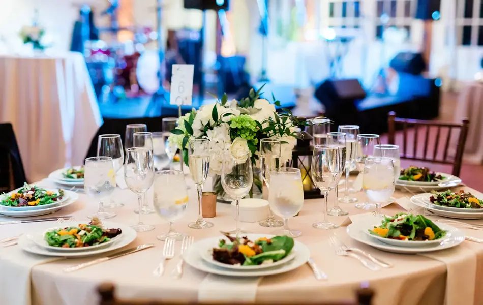 Rundt bryllupsbord med tallerkenretter. Foto til artikkel om bryllupsmenyer tilpasset sesong.
