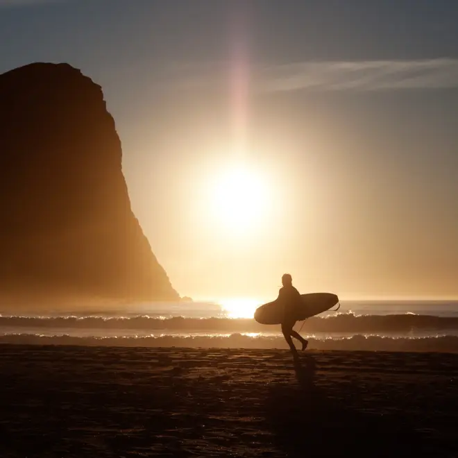 Surfer i solnedgang i Vestvågøy i Lofoten