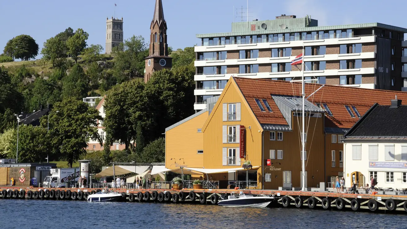 Fasaden til Thon Hotel Tønsberg Brygge med gule vegger og plassering på Brygga i Tønsberg sentrum
