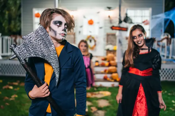 Young kids trick or treating at night during Halloween