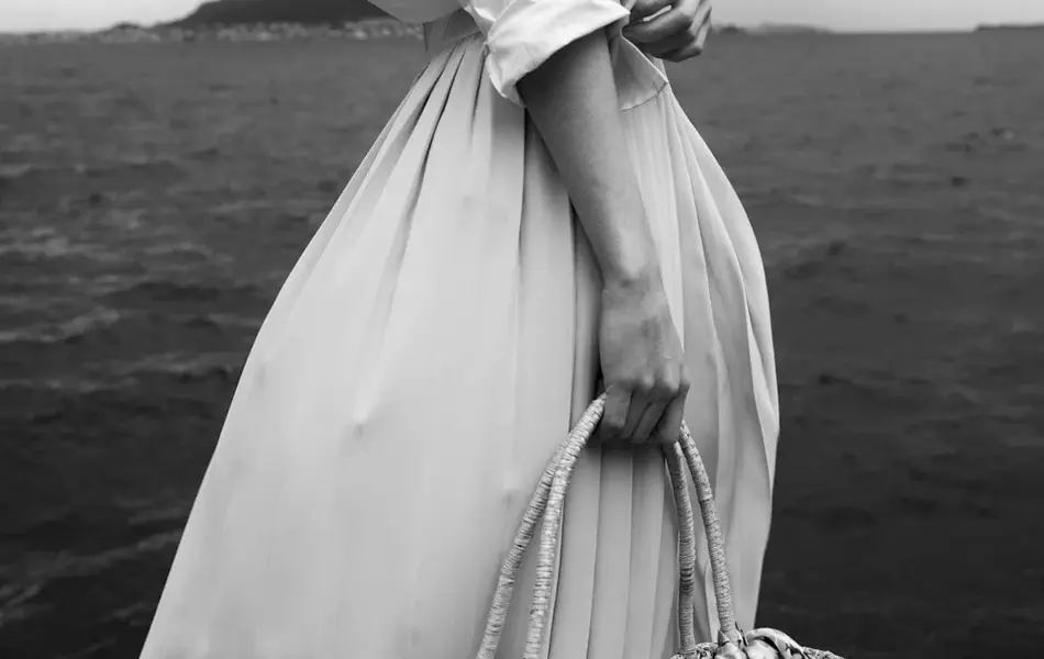 Ung jente poserer foran kamera med havet i bakgrunnen