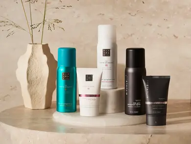 Rituals deodoranter i spray- og kremformat plassert på et bord ved en vase.