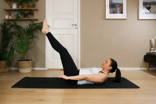 Anna viser Pilates-øvelser på treningsmatte på gulvet