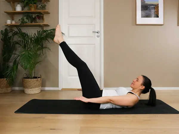 Anna viser Pilates-øvelser på treningsmatte på gulvet