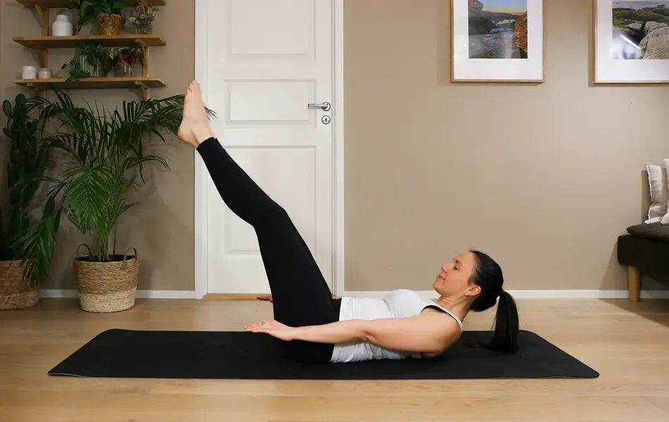 Anna viser Pilates-øvelser på treningsmatte på gulvet