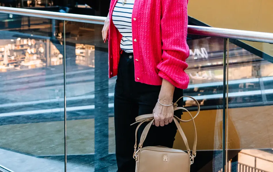 dame i vårklær står utenfor butikk