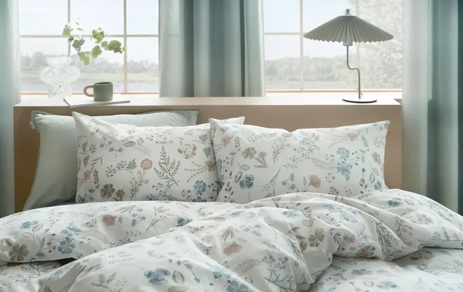 Seng med blomstrete sengetøy.