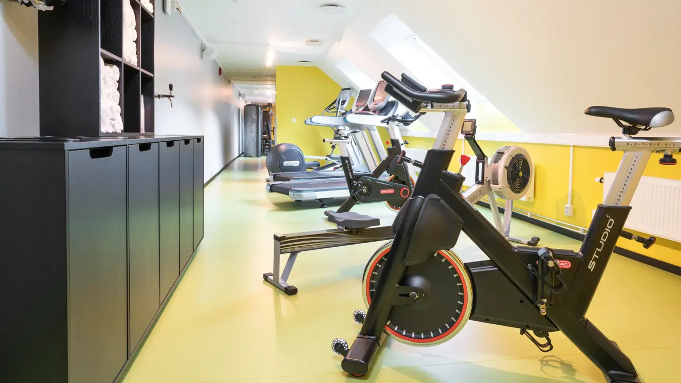 Lyse lokaler med gule gulv, spinningsykler i treningsrom på Thon Hotel Spectrum i Oslo sentrum