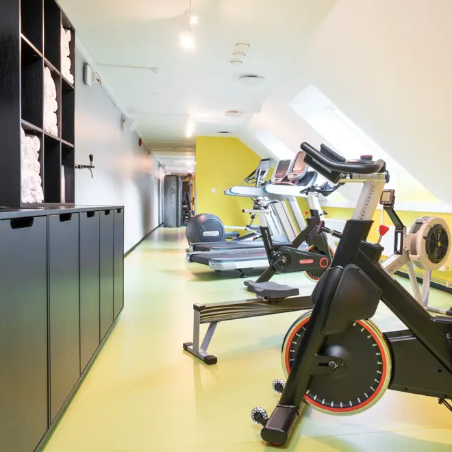 Lyse lokaler med gule gulv, spinningsykler i treningsrom på Thon Hotel Spectrum i Oslo sentrum