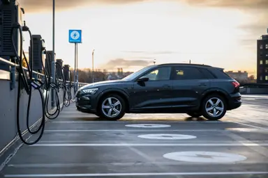 Bil på parkeringsplass med ladere